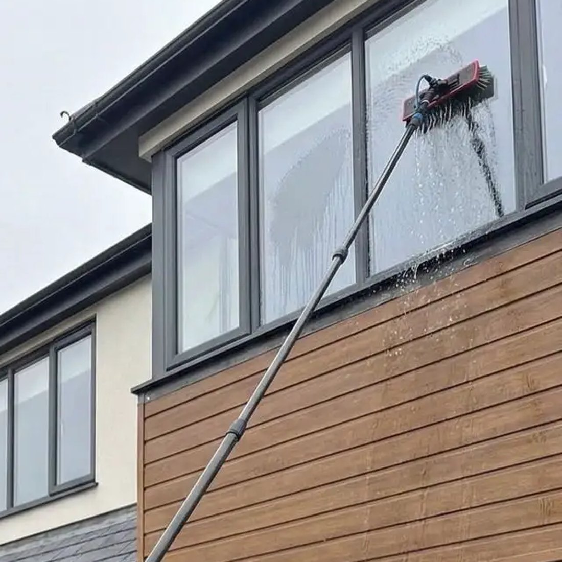 Pure water brush cleaning an upstairs window on a house in Essex